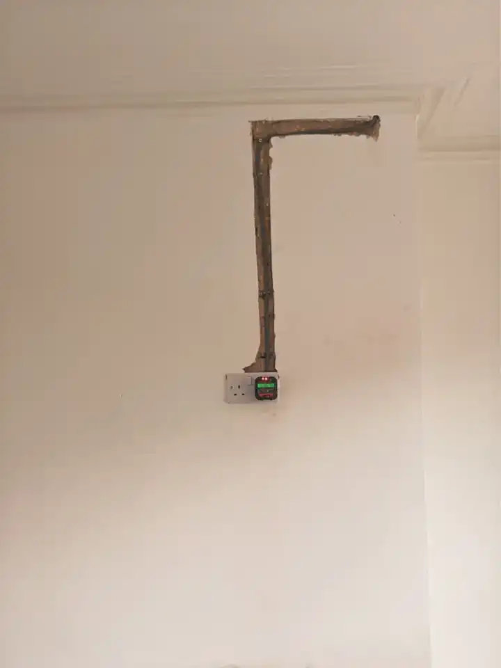 Fresh chase running from the coving down a chimney breast to a new double socket with a tester plugged in