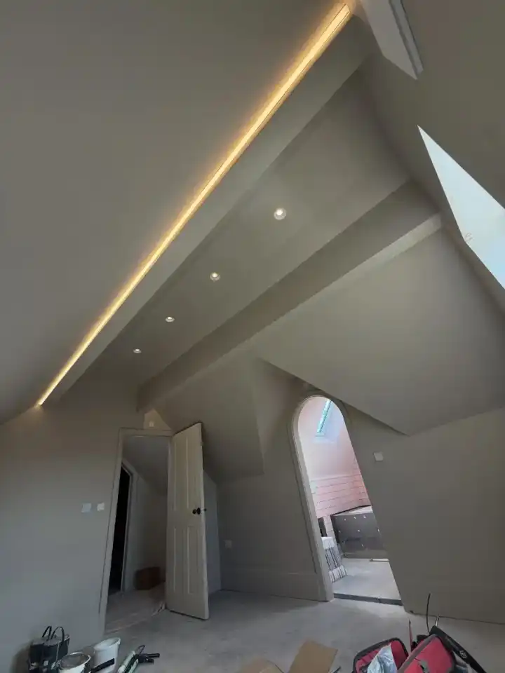 Warm LED strip lighting running along the pitched ceiling of a loft room in Manchester, fitted by FM Electrical